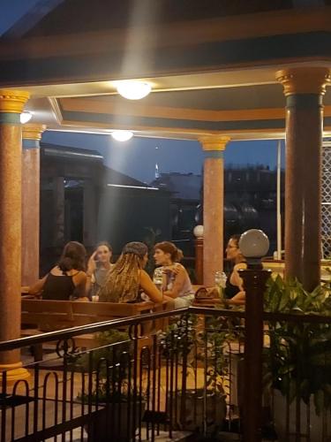 a group of people sitting at a bar at night at Saigon Rooftops Hostel in Ho Chi Minh City