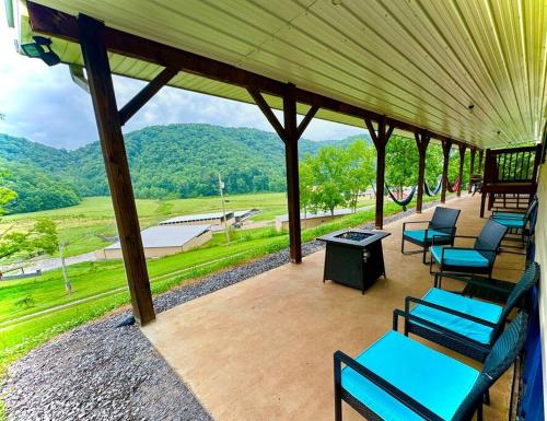a porch with blue chairs and a view of the mountains at Country views and hikes. in Kyles Ford