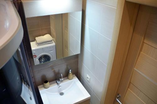 モスクワにあるCosy-3 Apartments na Kievskayaのバスルーム(シンク、鏡、洗濯機付)