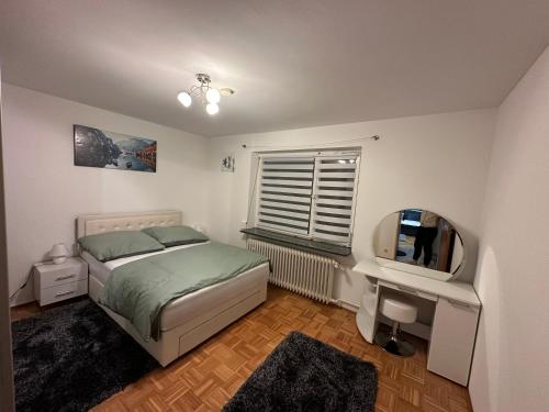 a bedroom with a bed and a desk and a television at Stilvolle 2-Zimmer-Anliegerwohnung in Tuttlingen in Tuttlingen