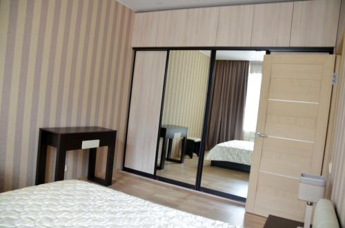モスクワにあるCosy-3 Apartments na Kievskayaのベッドと鏡が備わるホテルルーム