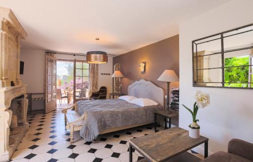 a bedroom with a bed and a fireplace at Hôtel du Clos in Le Rouret