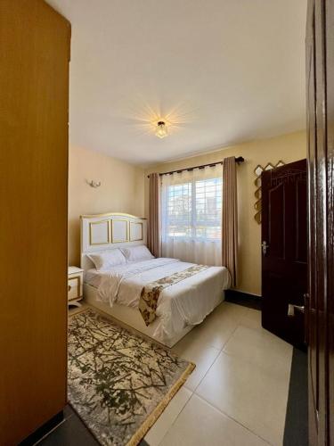a bedroom with a large bed and a window at Paradise palace in Nairobi