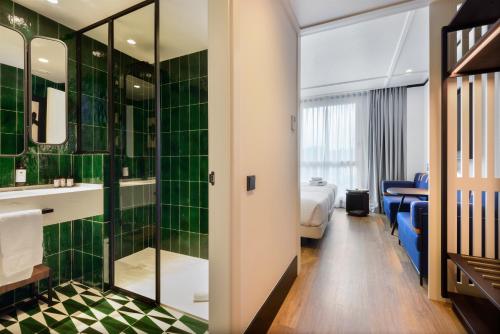 Habitación de hotel con baño de azulejos verdes en Hotel Tres Reyes San Sebastián en San Sebastián