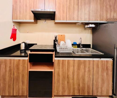 a kitchen with wooden cabinets and a sink at * * Y Stylish 2BR Option for 6 in Iloilo City