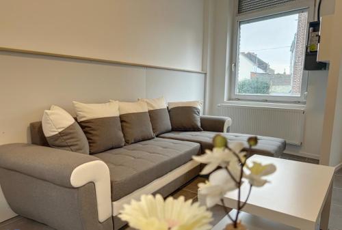 ein Wohnzimmer mit einem Sofa und einem Tisch in der Unterkunft Charbonnel 2 Bruxelles-Charleroi-airport in Charleroi
