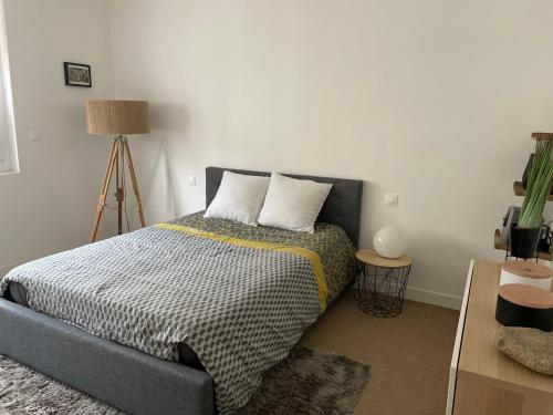 une chambre avec un lit avec deux oreillers dessus dans l'établissement Superbe appartement haut de gamme centre ville, au Mans