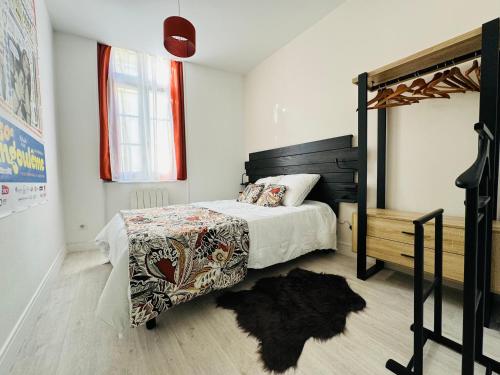une chambre avec un lit avec une tête de lit en bois dans l'établissement Cosy Louvel, Superbe apt au cœur d'Angoulême, à Angoulême