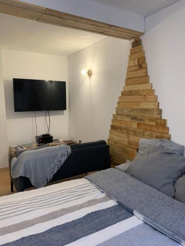 a room with two beds and a tv and a staircase at Le Studio de Ella in Bouxwiller