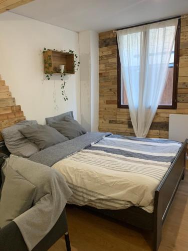 a bedroom with a large bed with a window at Le Studio de Ella in Bouxwiller