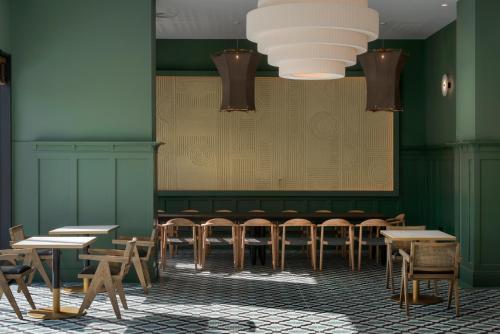 a dining room with green walls and tables and chairs at Hotel Tres Reyes San Sebastián in Donostia-San Sebastián