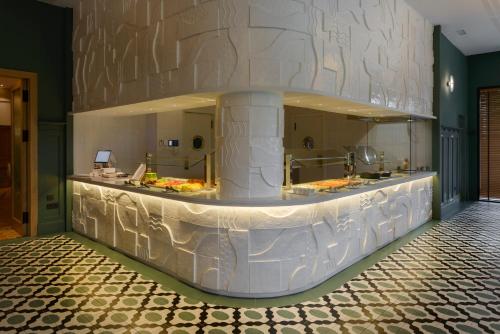 a lobby with a large white counter in a building at Hotel Tres Reyes San Sebastián in Donostia-San Sebastián