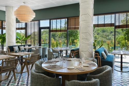a restaurant with tables and chairs and large windows at Hotel Tres Reyes San Sebastián in Donostia-San Sebastián
