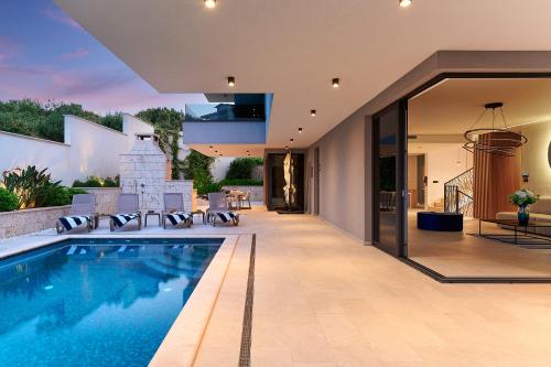 an external view of a house with a swimming pool at Villas Lucy - 1 Lemon -outdoor pool , 2 Cherry-indoor pool and 3 Plum-outdoor pool in Marina