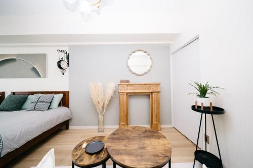 a room with a bed and a wooden table at D91新宿最中心 東新宿站5分-Shinjuku center 5 mins to Station, Max 4P 直达新宿 涉谷 表参道 池袋 上野 代代木 银座 原宿 in Tokyo