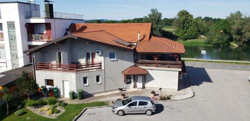 a house with a car parked in front of it at Guesthouse Kod mosta in Karlovac