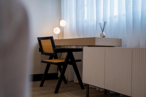 a wooden desk with a chair next to a curtain at Hotel Marcos Gamero in Talca