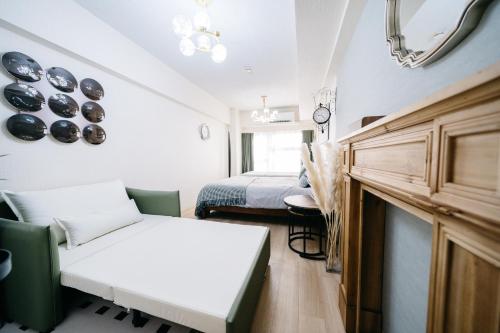 a room with two beds and a couch and a mirror at D91新宿最中心 東新宿站5分-Shinjuku center 5 mins to Station, Max 4P 直达新宿 涉谷 表参道 池袋 上野 代代木 银座 原宿 in Tokyo