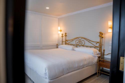 a bedroom with a bed with white sheets and pillows at Hotel Marcos Gamero in Talca
