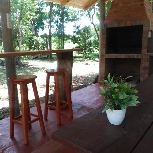 a patio with a table and two stools and a fireplace at Cabaña Don Lorenzo in Puerto Victoria