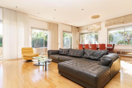 卡薩布蘭卡的住宿－Luxury villa Bouskoura Pearl，客厅配有真皮沙发和桌子
