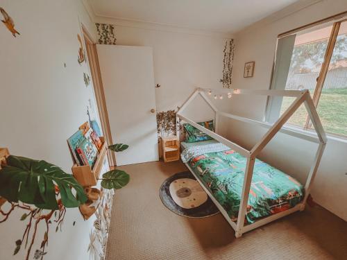 ein kleines Zimmer mit einem Etagenbett und einem Fenster in der Unterkunft BEACH 400m, Big Yard, Playroom, Perfect for Families, Couples, Digital Nomads in Mandurah