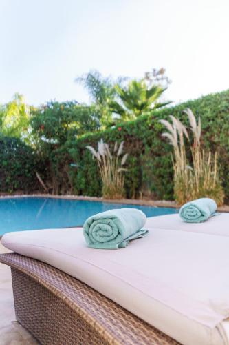 a bed with towels on it next to a pool at Luxury villa Bouskoura Pearl in Casablanca