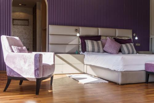 a bedroom with a large bed and a chair at Luxury villa Bouskoura Pearl in Casablanca
