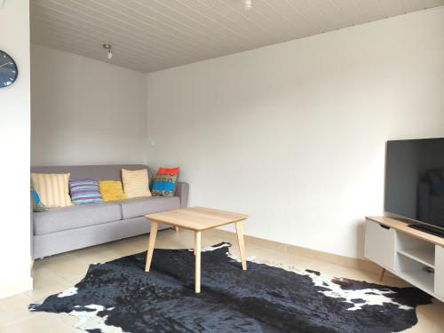 a living room with a couch and a table at La Maison Rose - La Bresse in La Bresse