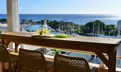 a table on a balcony with a view of the ocean at Kaz a Soley - Gîte vue panoramique sur la mer - Plage à 500m in Gourbeyre