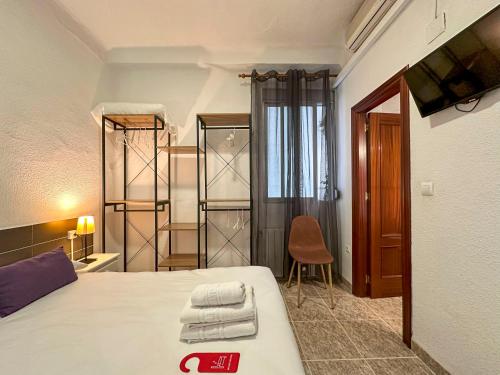 a bedroom with a bed and a tv in a room at Pensión Recogidas in Granada