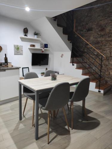 une salle à manger avec une table, des chaises et un escalier dans l'établissement O Refúgio das Buracas, à Condeixa-a-Nova