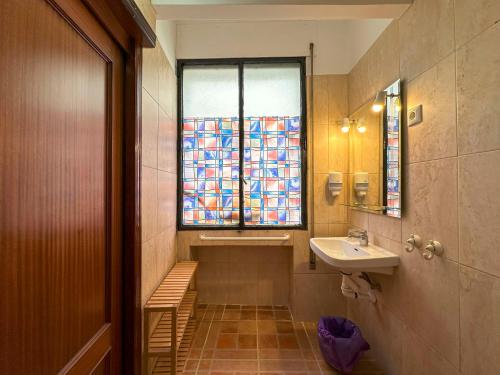 baño con lavabo y ventana en Pensión Recogidas, en Granada