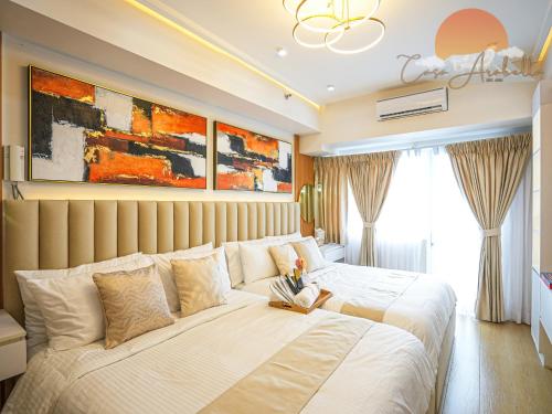 a bedroom with a large bed with white sheets at Casa Arabella - Wind Residences Tower 5 2018 in Tagaytay
