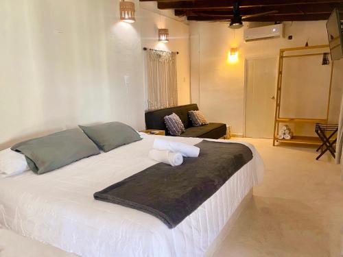 sypialnia z dużym białym łóżkiem z ręcznikami w obiekcie Casa Lucia Beachfront Puerto Morelos w mieście Puerto Morelos