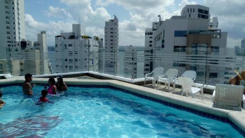 a family in a swimming pool on the roof of a building at BARLOVENTO in Cartagena de Indias