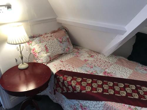 a bedroom with a bed and a table with a lamp at Penzance Seaside studios in Penzance