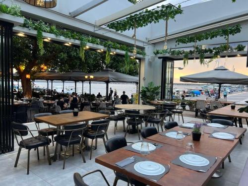 a restaurant with tables and chairs and a view of the ocean at Panellinion Luxury Rooms in Kalamata