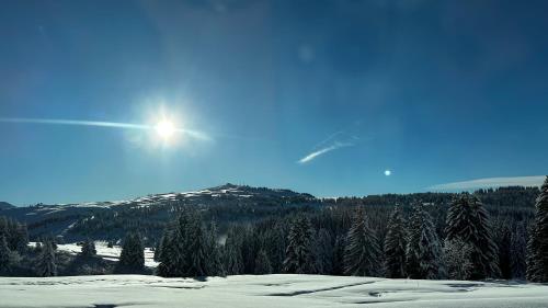 una montaña cubierta de nieve con el sol en el cielo en Chez Chris et Gildas, en Gilly-sur-Isère