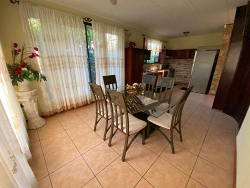 uma sala de jantar com uma mesa de vidro e cadeiras em Casa Brisa Marina, Comfy Villa for 7 with Private Pool, Just 10 Minutes from Manuel Antonio! em Quepos