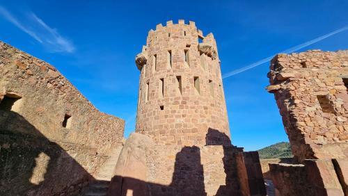 a tall brick tower with a blue sky in the background at Casa Turistica Torreón de Villafamés in Villafamés