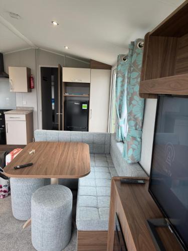 a living room with a dining table and a kitchen at Perranporth Holiday Park in Perranporth
