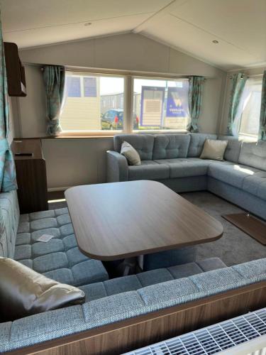 a living room with a couch and a table at Perranporth Holiday Park in Perranporth