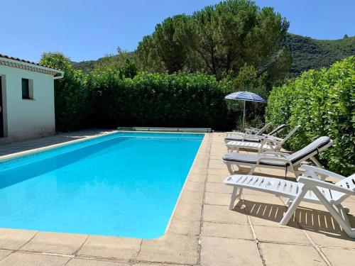 a swimming pool with lounge chairs and an umbrella at Gîte 45 m2 3/4 personnes in Bessèges