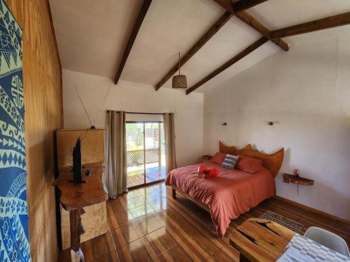 a bedroom with a bed and a television in a room at Cabañas Kainga in Hanga Roa