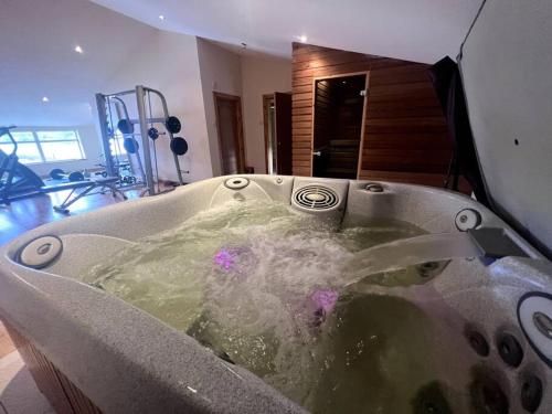 a bath tub filled with water in a gym at Langside apartments in Newhouse