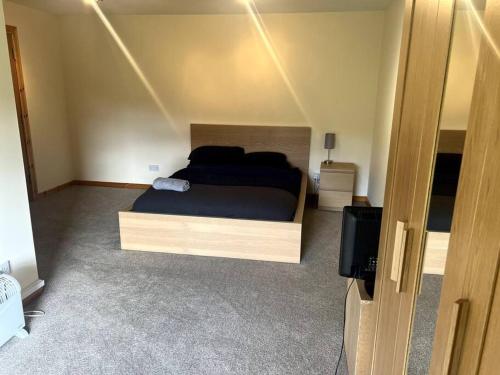 um quarto com uma cama e uma televisão em Kensington Apartments em Newhouse