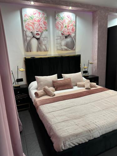 a bedroom with a large bed with two paintings on the wall at Habitación LUXURY LOVE in Sant Carles de la Ràpita