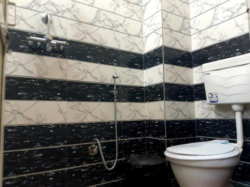 a bathroom with a toilet and black and white tiles at Ali Baba Hostel & Homestay in Jaipur