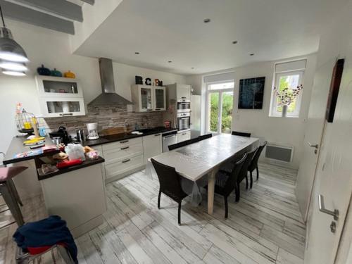 une cuisine avec une table et quelques chaises dans l'établissement Belle villa 150 m Carnac plage, à Carnac